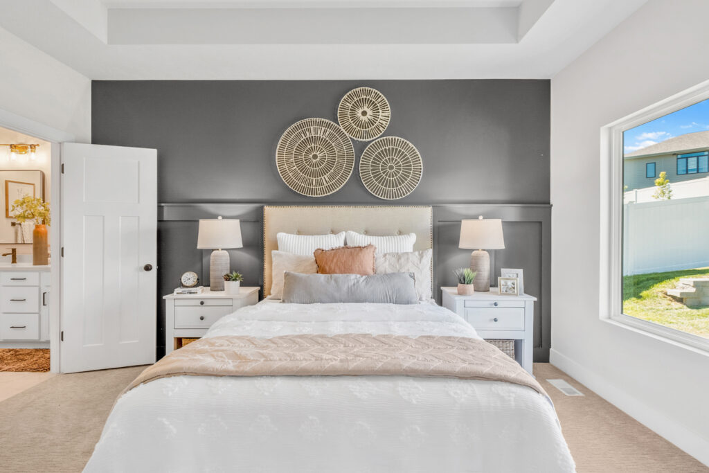 Bedroom with accent wall, open window, and door to bathroom