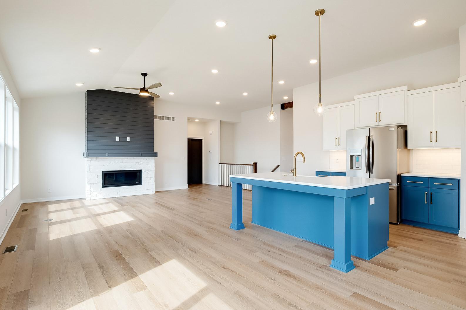 Kitchen leading to living room fireplace and hallway of bedrooms.